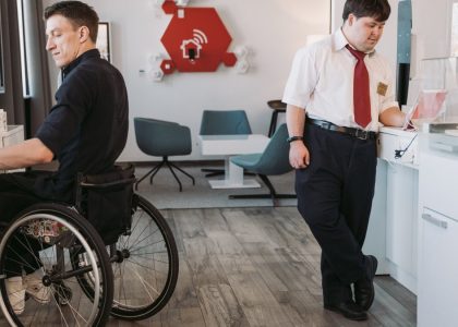 Two male employees working in an inclusive office setting, showcasing accessibility and diversity.